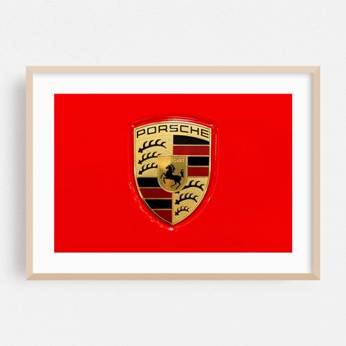 Porsche car brand logo on a shiny red car hood closeup, macro, detail, top view, classic Porsche AG Stuttgard company emblem isolated, logo from above